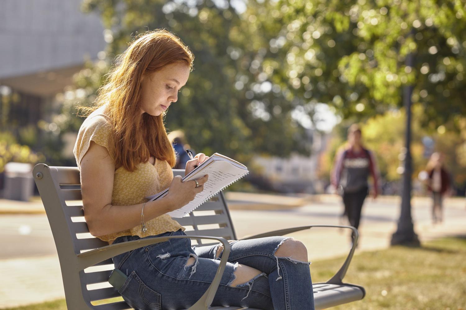 一位<a href='http://yzed.techgyaani.com'>全球十大赌钱排行app</a>学院的学生在校园里的长椅上读书.